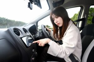 27630648_s | 車買取のソコカラ カーナビの調子が悪く、取り外して新しいカーナビに替えるか検討している女性