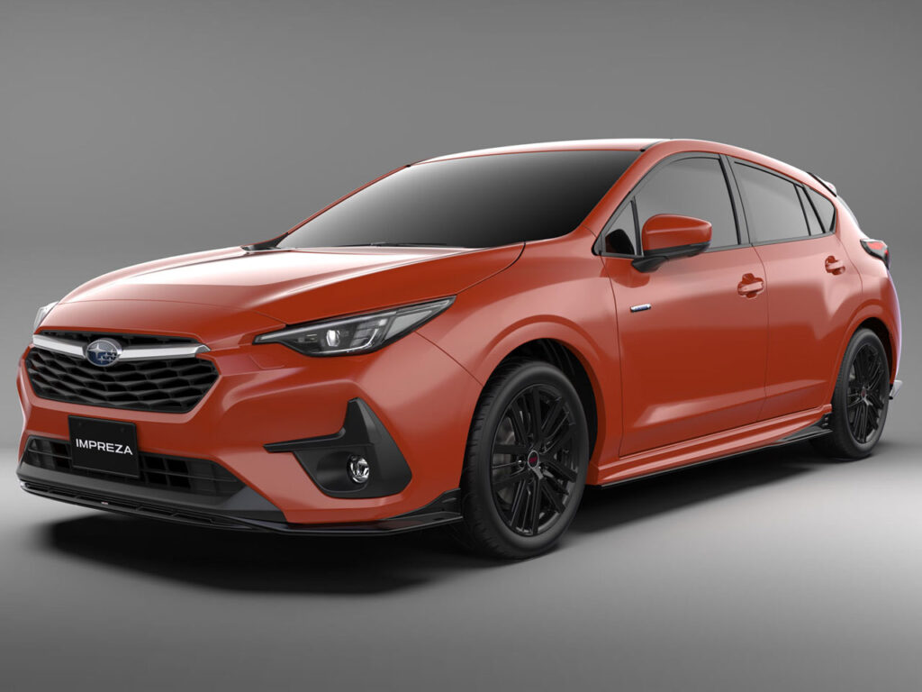 インプレッサ 2023 | 車買取のソコカラ Front three-quarter view of a red Subaru Impreza hatchback on a neutral gray studio background, showing black wheels and sleek headlights.