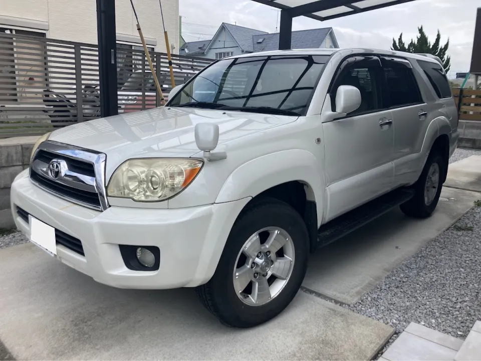 White Toyota SUV parked on a concrete driveway under a carport, shown from the front‑right three‑quarter view.